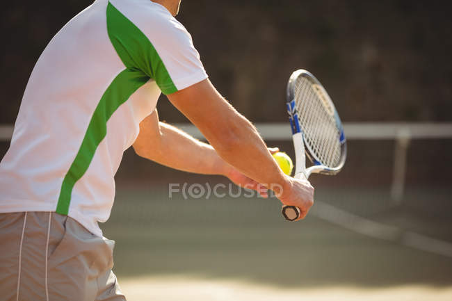 Человек с теннисной ракеткой готов служить на спортивном корте — стоковое фото