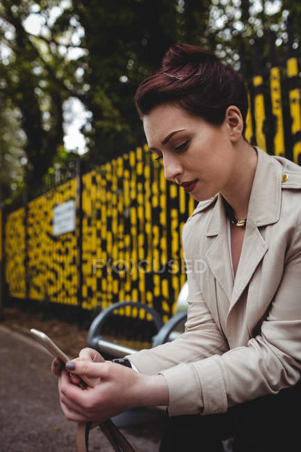 Mulher bonita usando telefone celular na plataforma estação ferroviária — Fotografia de Stock