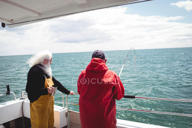 Zwei Fischer angeln mit Angelrute vom Boot aus — Stockfoto