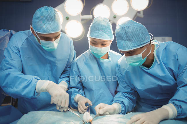 Команда хирургов, выполняющих операции в операционной в больнице — стоковое фото