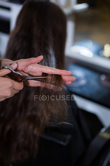Mujer consiguiendo su pelo recortado en el salón - foto de stock