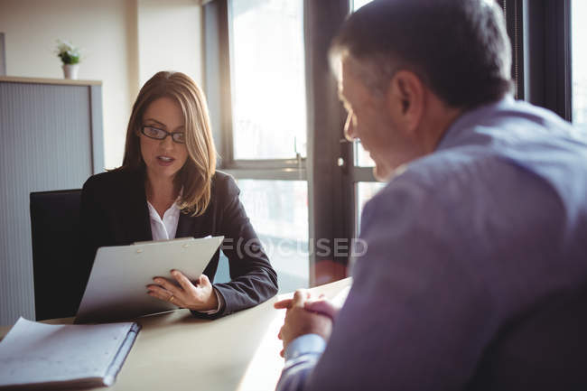 Mujer de negocios en discusión con su colega en el cargo - foto de stock