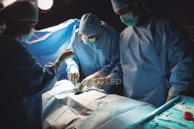 Team of surgeons performing operation in operation room at hospital — Stock Photo