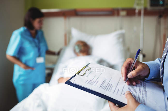Hände eines männlichen Arztes bei der Erstellung eines medizinischen Berichts im Krankenhaus — Stockfoto