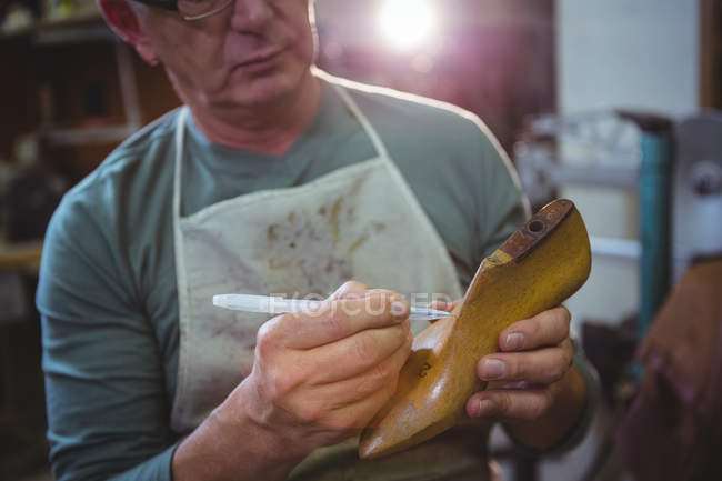 Sapateiro marcação na última sapato com caneta na oficina — Fotografia de Stock