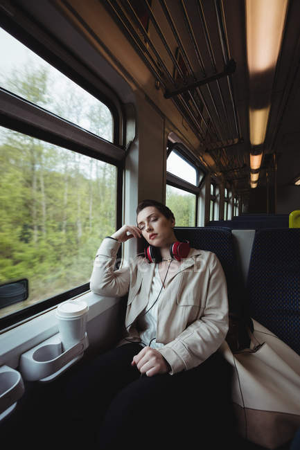 Красивая женщина спит у окна в поезде — стоковое фото