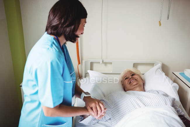 Enfermera consoladora paciente mayor en el hospital - foto de stock