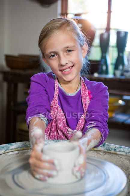 Портрет счастливой девушки, делающей горшок в мастерской по керамике — стоковое фото