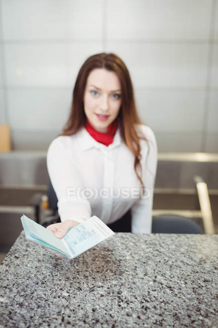 Assistente de check-in da companhia aérea que dá passaporte no balcão de check-in do aeroporto — Fotografia de Stock