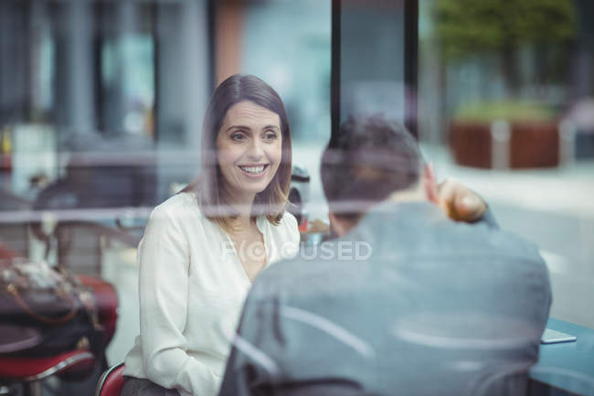 Hombre y mujer conversando en la cafetería - foto de stock
