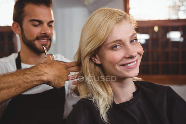 Жінка отримує її волосся оброблені ножицями в салоні — стокове фото