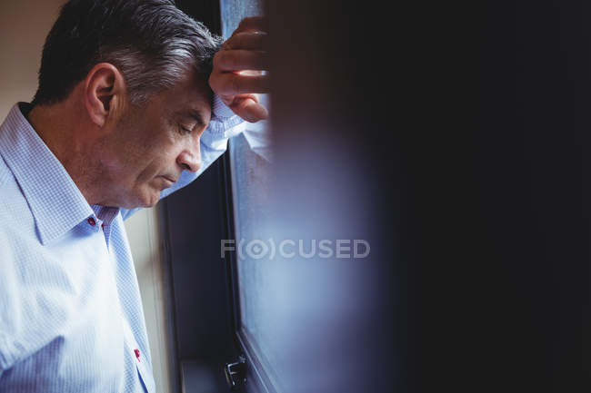 Close-up of doctor standing near window in hospital — Stock Photo