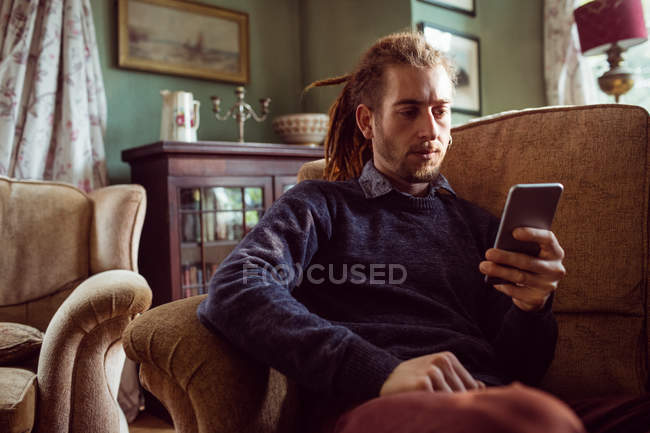 Jeune homme utilisant un téléphone portable — Photo de stock