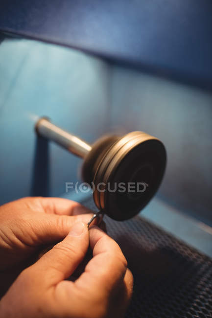 Close-up of goldsmith polishing ring in workshop — Stock Photo