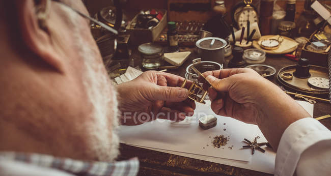 Horólogo reparando un reloj en el taller - foto de stock