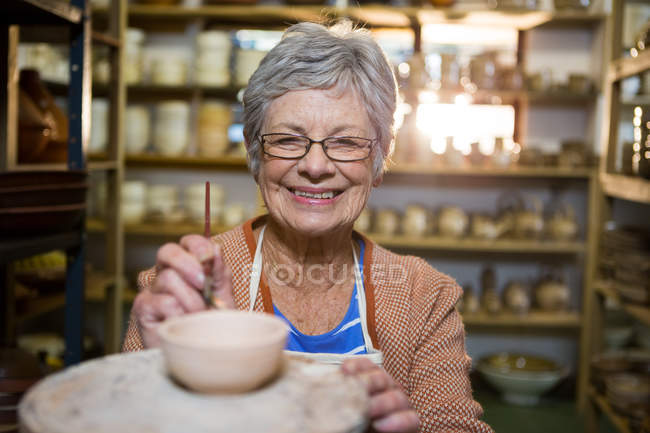 Retrato de pintura oleiro feminino na tigela em oficina de cerâmica — Fotografia de Stock