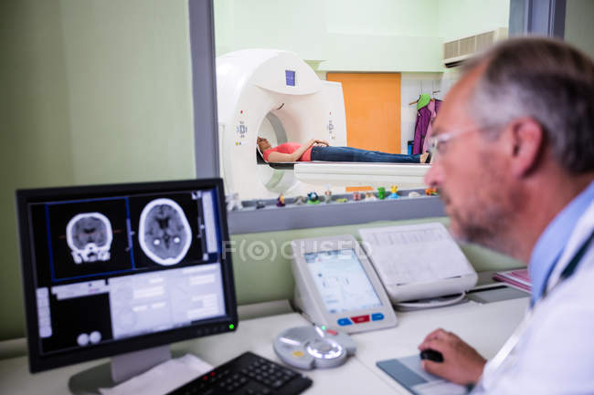 Médico examinando resonancia magnética cerebral en computadora en el hospital - foto de stock