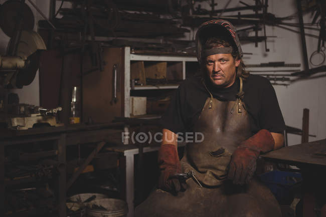 Portrait of blacksmith in protective helmet at work shop — Stock Photo