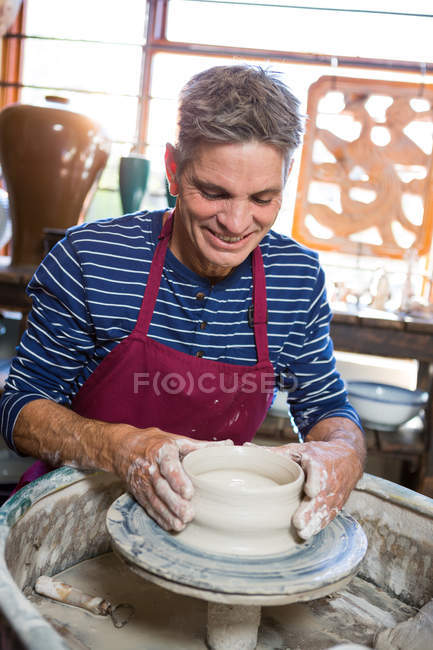 Potier masculin heureux faisant pot dans l'atelier — Photo de stock