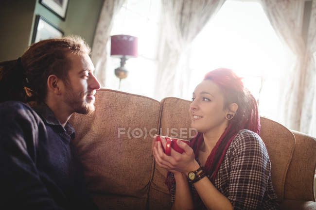 Joven pareja hipster relajándose en el sofá en casa - foto de stock
