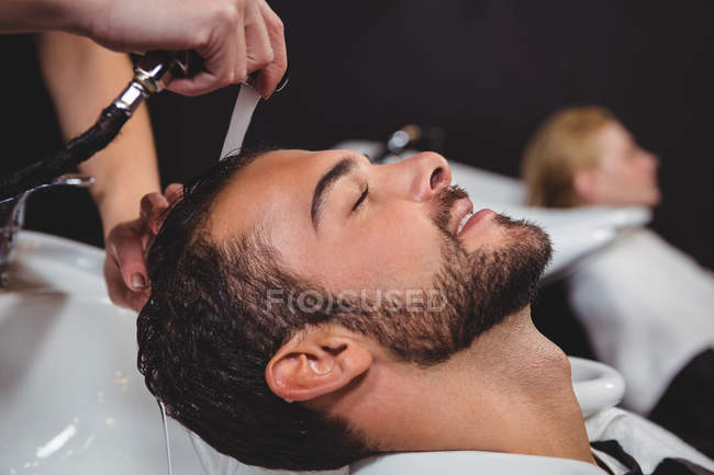 Un homme se lave les cheveux au salon — Photo de stock