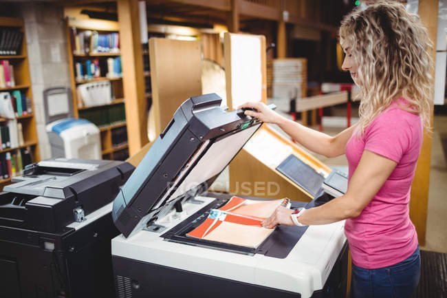 Frau benutzt Kopiergerät in Bibliothek — Stockfoto