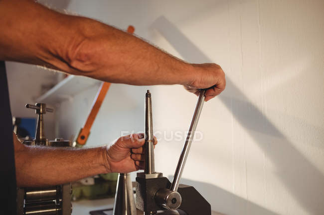 Mid section of goldsmith using mini drill press in workshop — Stock Photo
