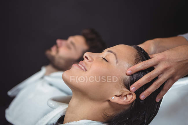 Clientes lavándose el pelo en el salón - foto de stock