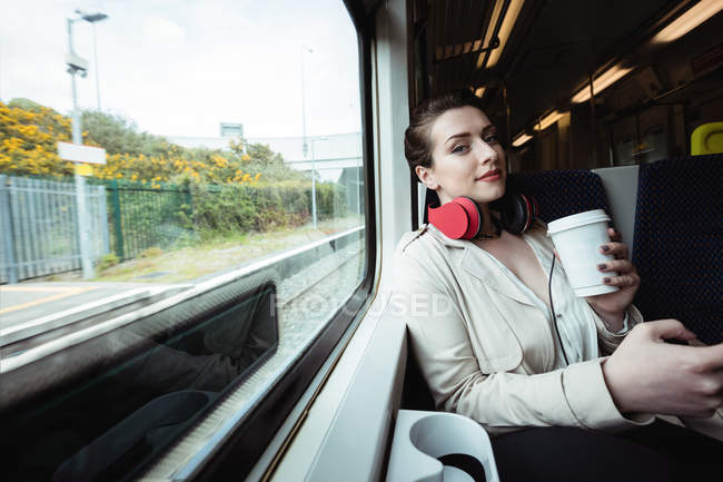 Портрет красивой женщины, сидящей у окна в поезде — стоковое фото