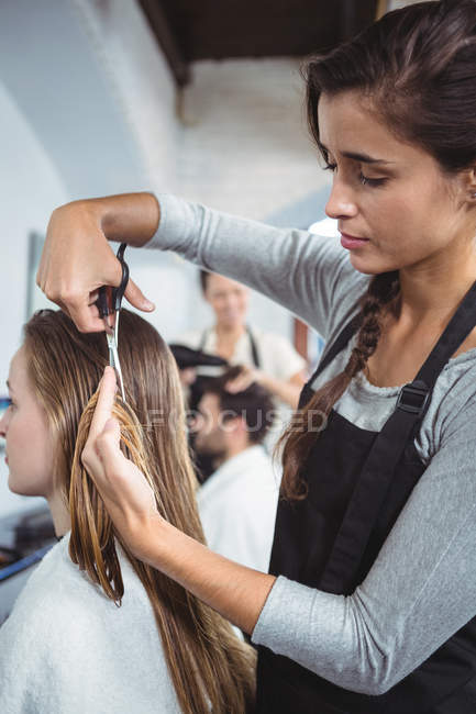 Mujer consiguiendo su pelo recortado en salón - foto de stock