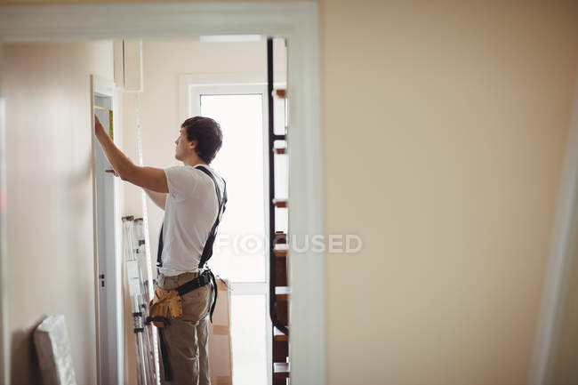 Carpintero trabajando en la puerta de madera en casa - foto de stock