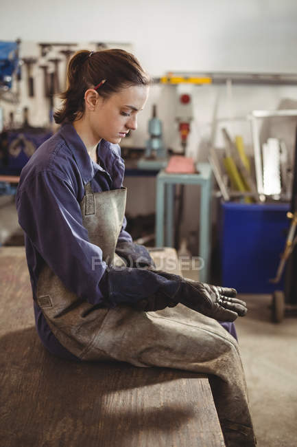 Female welder wearing glove in workshop — Stock Photo