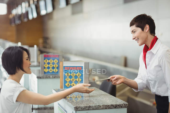 Регистрация на рейс сопровождающего, вручение паспорта пассажиру на стойке регистрации в аэропорту — стоковое фото