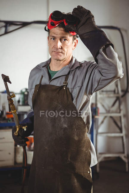 Retrato de soldador de pé com máquina de solda na oficina — Fotografia de Stock