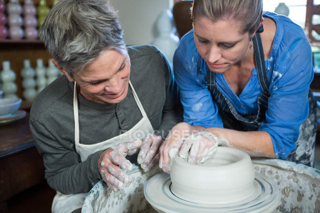 Potier masculin assistant potier féminin dans l'atelier de poterie — Photo de stock