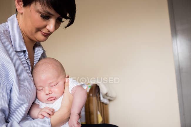 Mother holding baby while he sleeping at home — Stock Photo