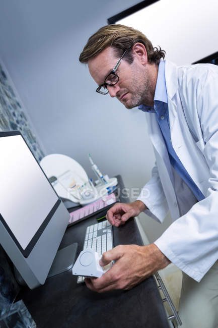 Dentista trabalhando em computador na clínica odontológica — Fotografia de Stock