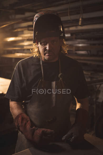 Retrato de ferreiro em capacete de proteção na oficina — Fotografia de Stock