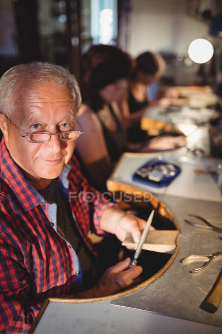 Уважний старший чоловік золотошукач формує деревину в майстерні — стокове фото