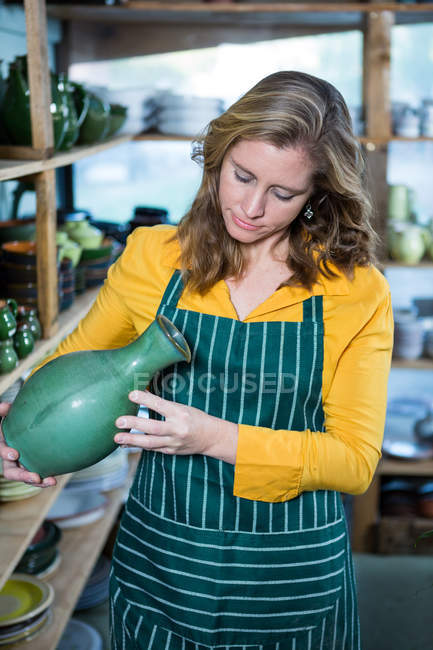 Ceramista donna che controlla pentola in laboratorio di ceramica — Foto stock