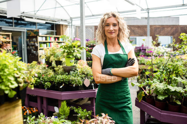 Portrait of female florist standing with arms crossed in garden centre — Stock Photo