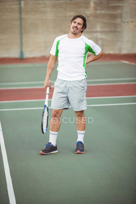 Втомлений тенісист стоїть на спортивному корті з ракеткою — стокове фото