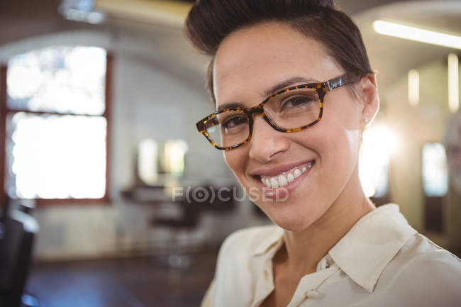Retrato de sorrindo cabeleireiro feminino no salão — Fotografia de Stock