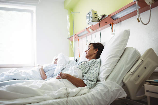 Pacientes dormindo em uma cama na enfermaria do hospital — Fotografia de Stock