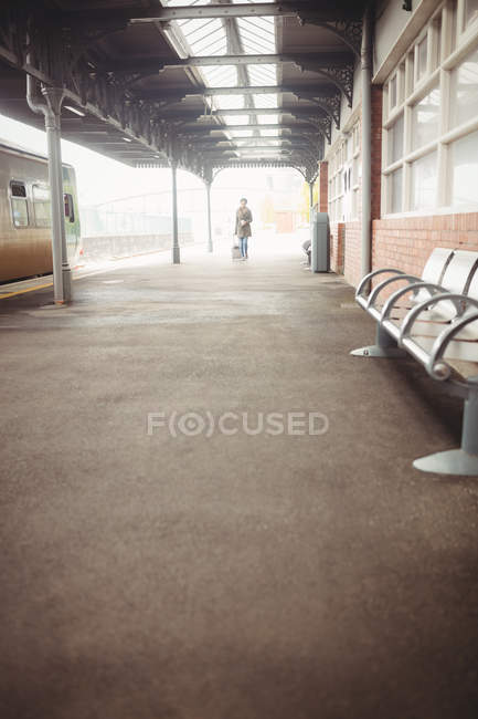 Vista à distância da mulher em pé na plataforma da estação ferroviária — Fotografia de Stock