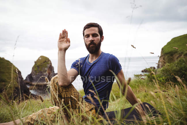Чоловік виконує йогу на скелі — стокове фото