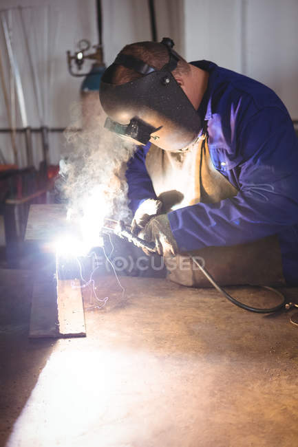 Сварщик сварочный металл в мастерской — стоковое фото