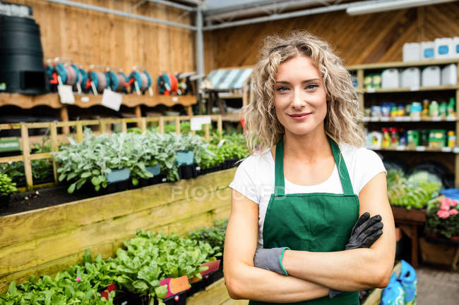 Portrait of female florist standing with arms crossed in garden centre — Stock Photo