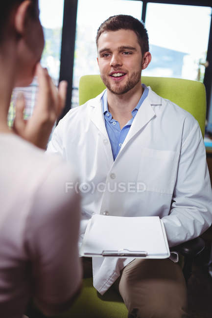 Physiotherapist explaining diagnosis to female patient in clinic — Stock Photo