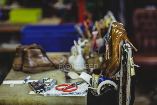 Обувной инструмент и высокие каблуки в мастерской — стоковое фото